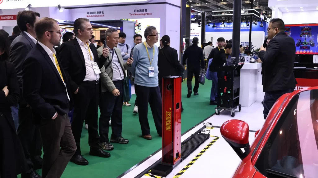GATmatic staff introducing a touchless wheel aligner to customers at Automechanika Shanghai 2025.